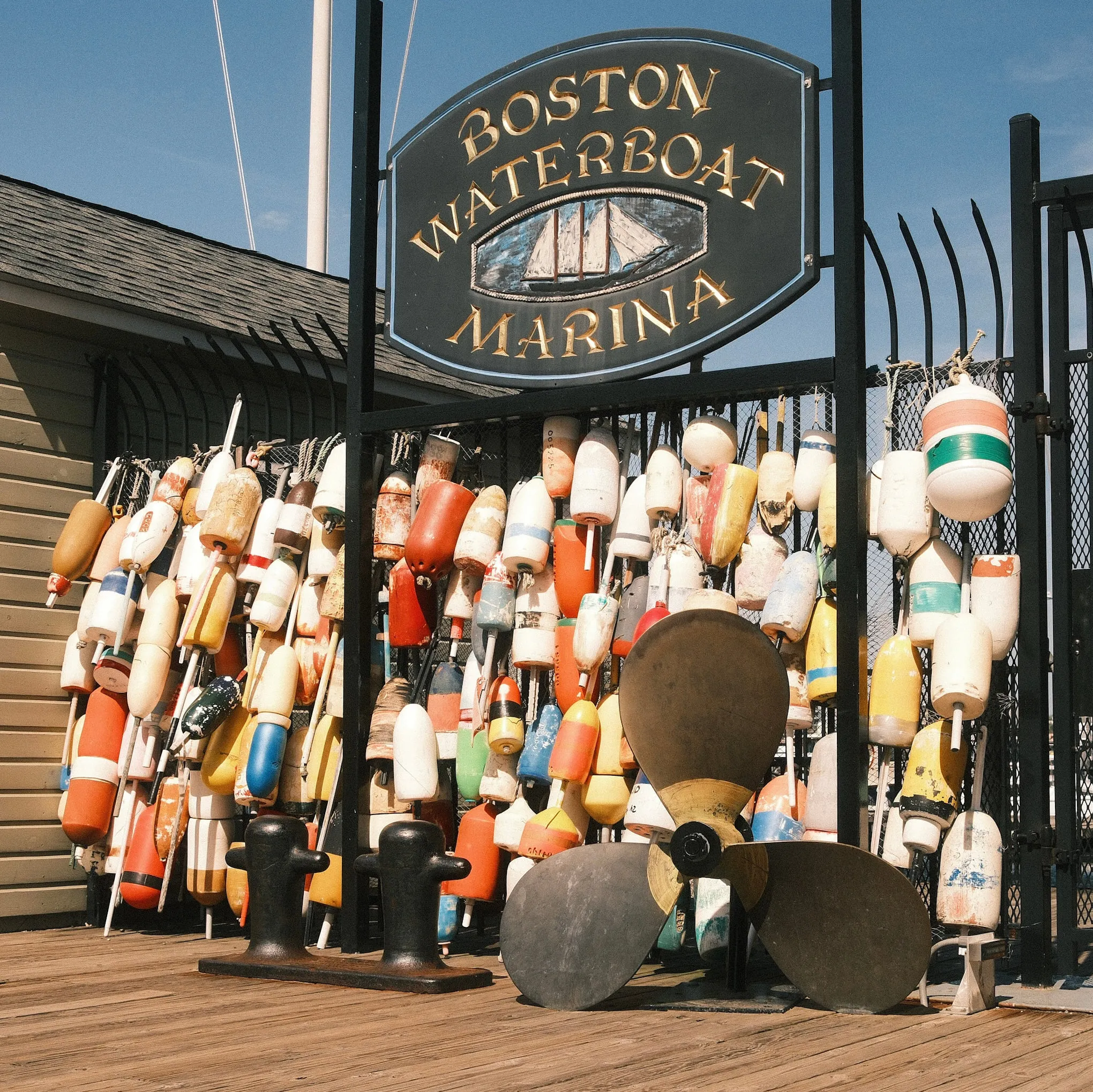 Buoys and a propeller stacked outside the marina office.