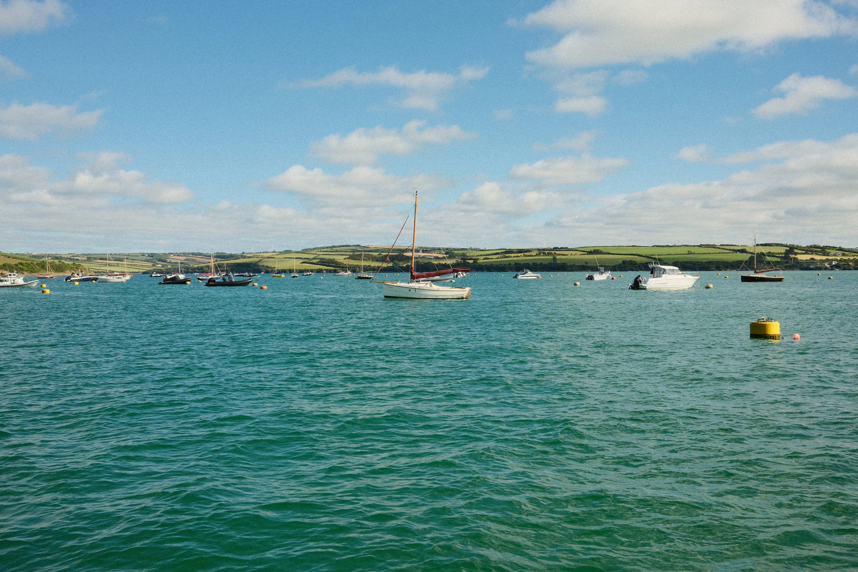 Moorings on a bright day, hills across the water.